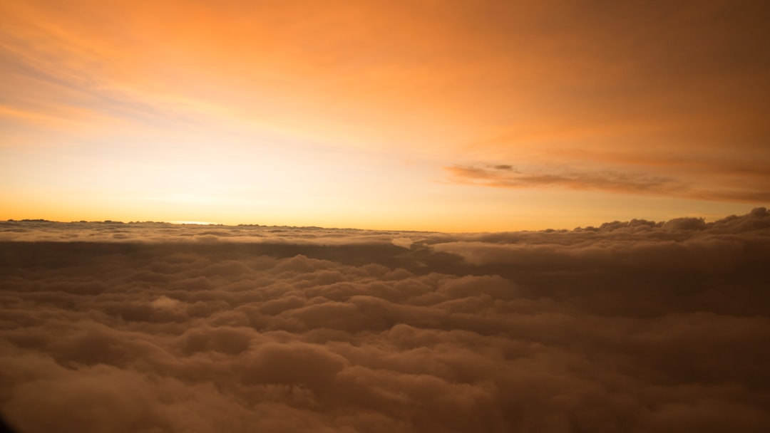 Vue depuis un hublot d'avion sur une mer de nuages au coucher du soleil